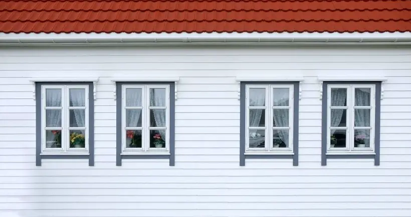 Ein rotes Ziegeldach über weißer Fassade und Fenstern