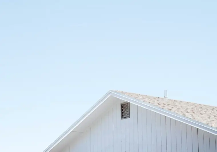 Der weiße Giebel eines Hauses vor klarem Himmel